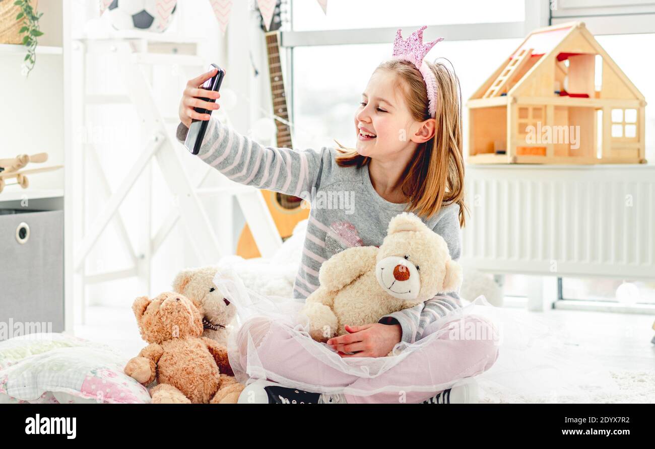 Happy little girl taking photo with toys in cute playroom Stock Photo ...