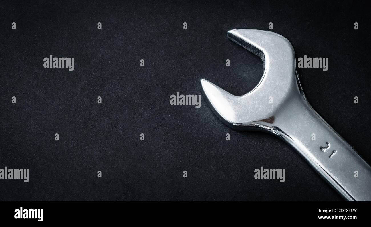 Metallic hand wrench on dark background with copy space Stock Photo