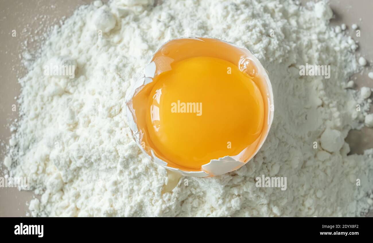 Broken raw chicken egg with flour, top view Stock Photo