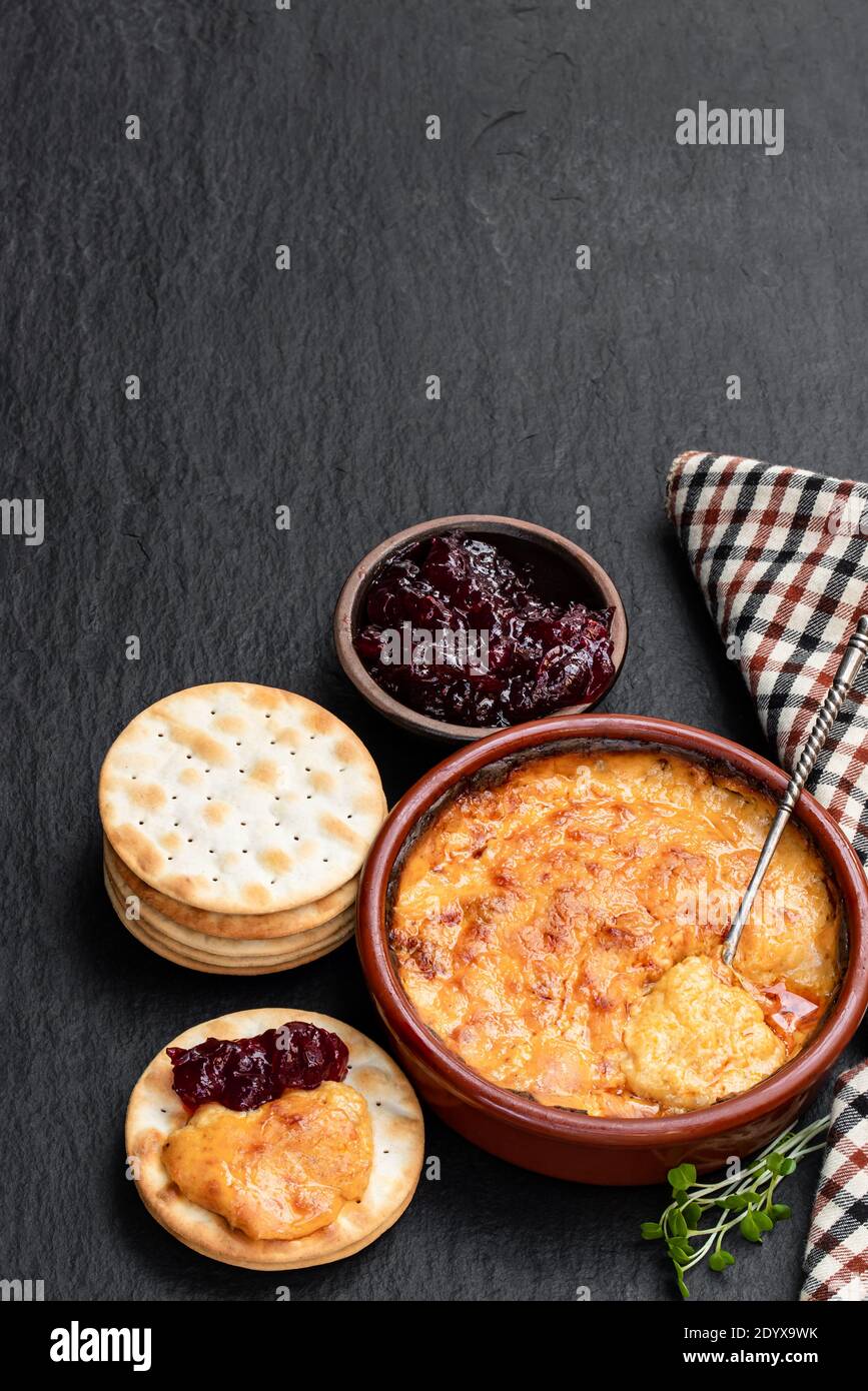 Baked mature cheddar cheese with spanish chorizo on black stone