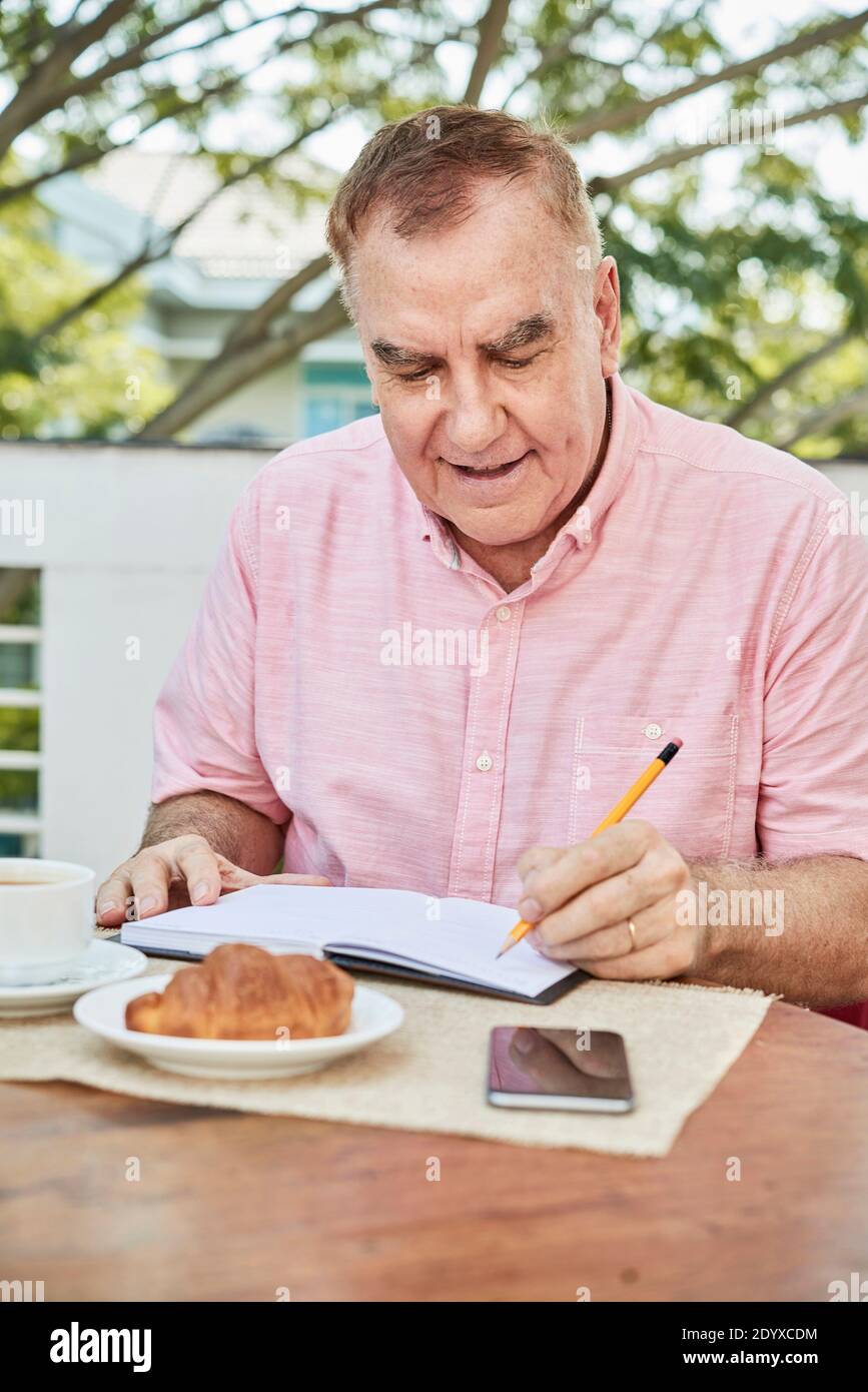 Senior man filling planner Stock Photo