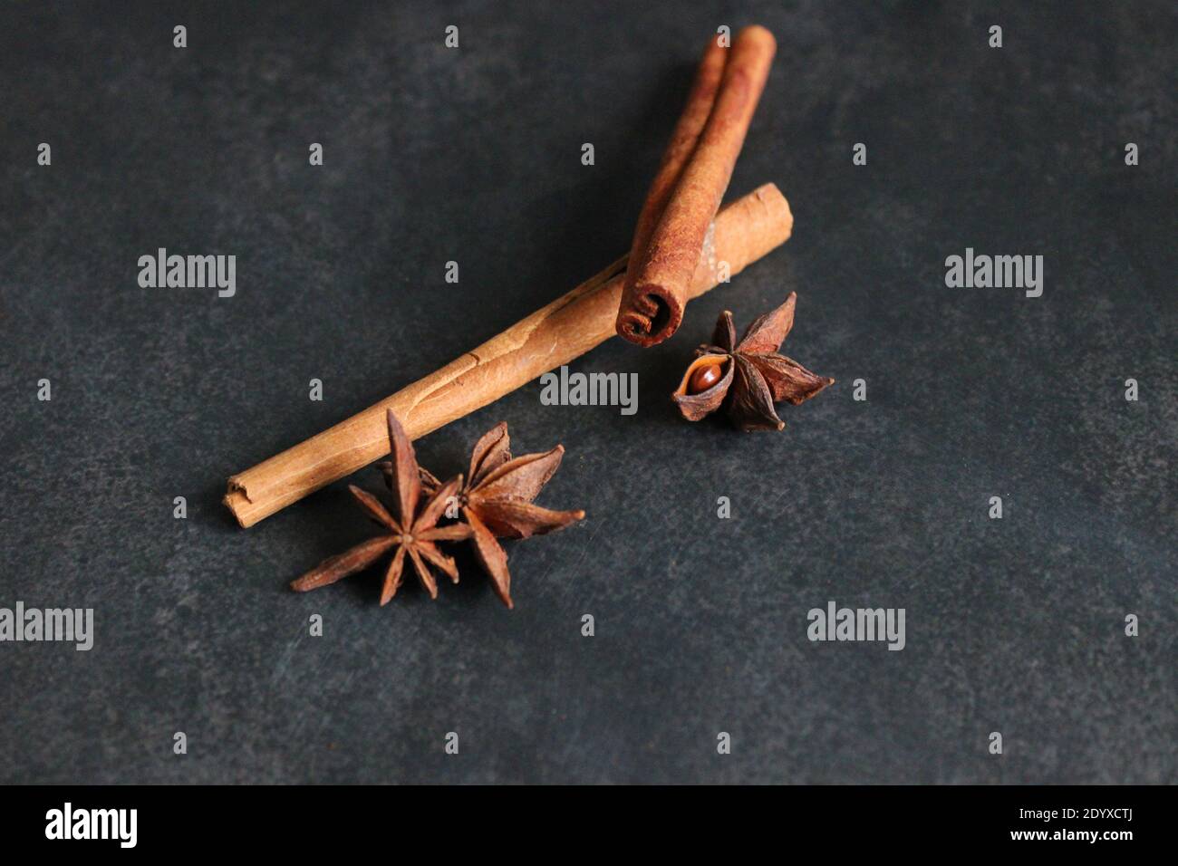 Spices on a dark background. Cinnamon sticks and anise stars. Stock Photo