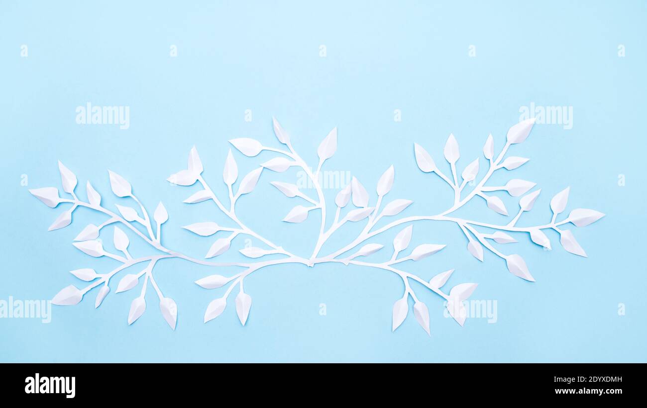 white paper flowers and leaves on blue background Stock Photo - Alamy