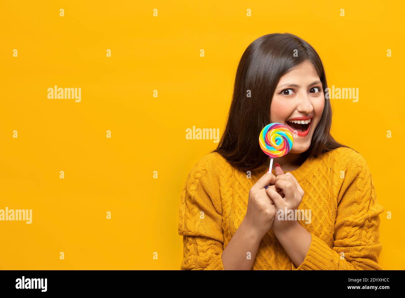 Young woman laughing with excitement holding a lollipop Stock Photo