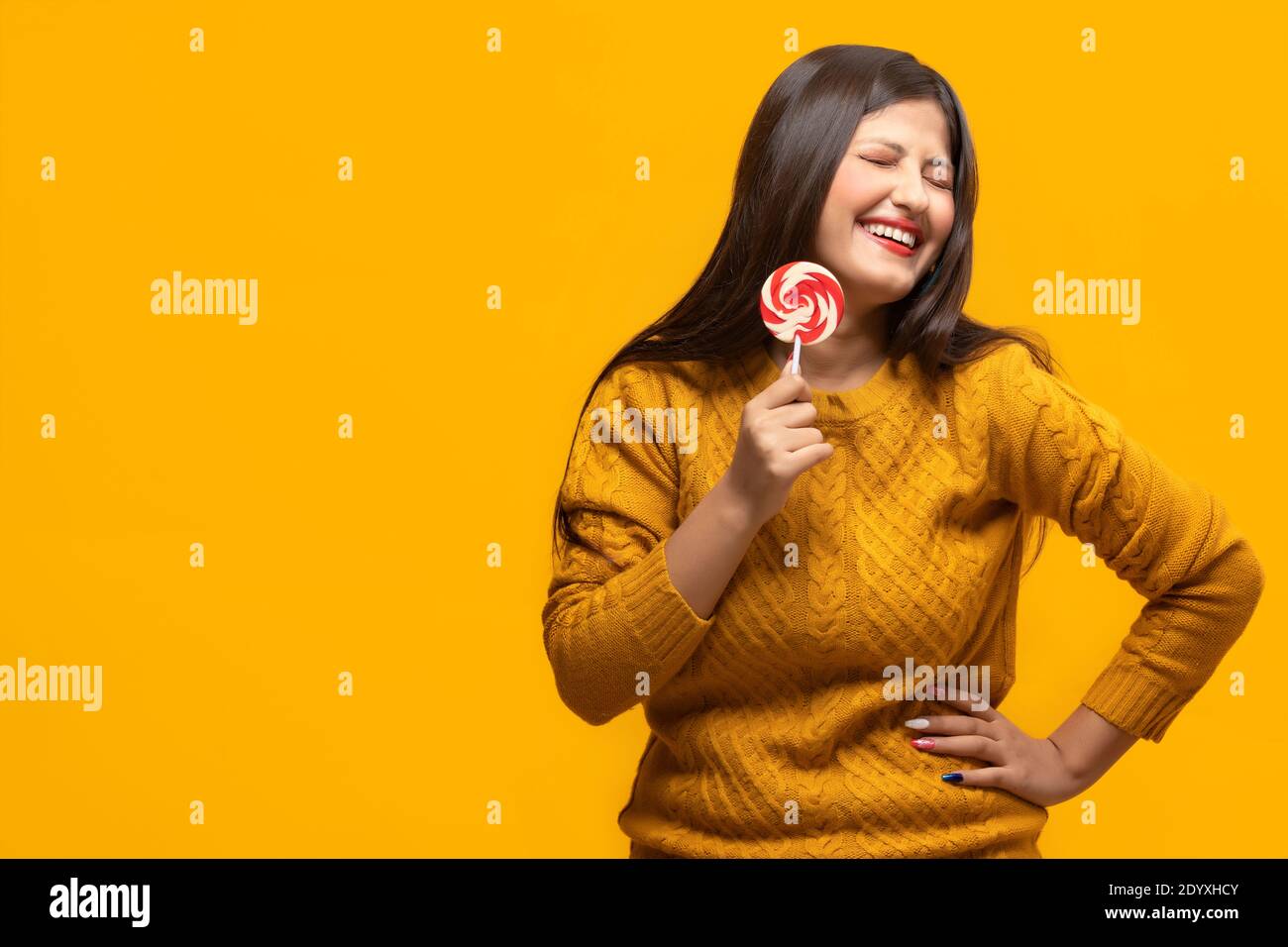 Young woman laughing holding a lollipop in hand Stock Photo