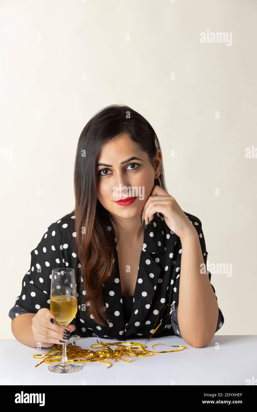 Young woman sitting at table with champagne glass Stock Photo