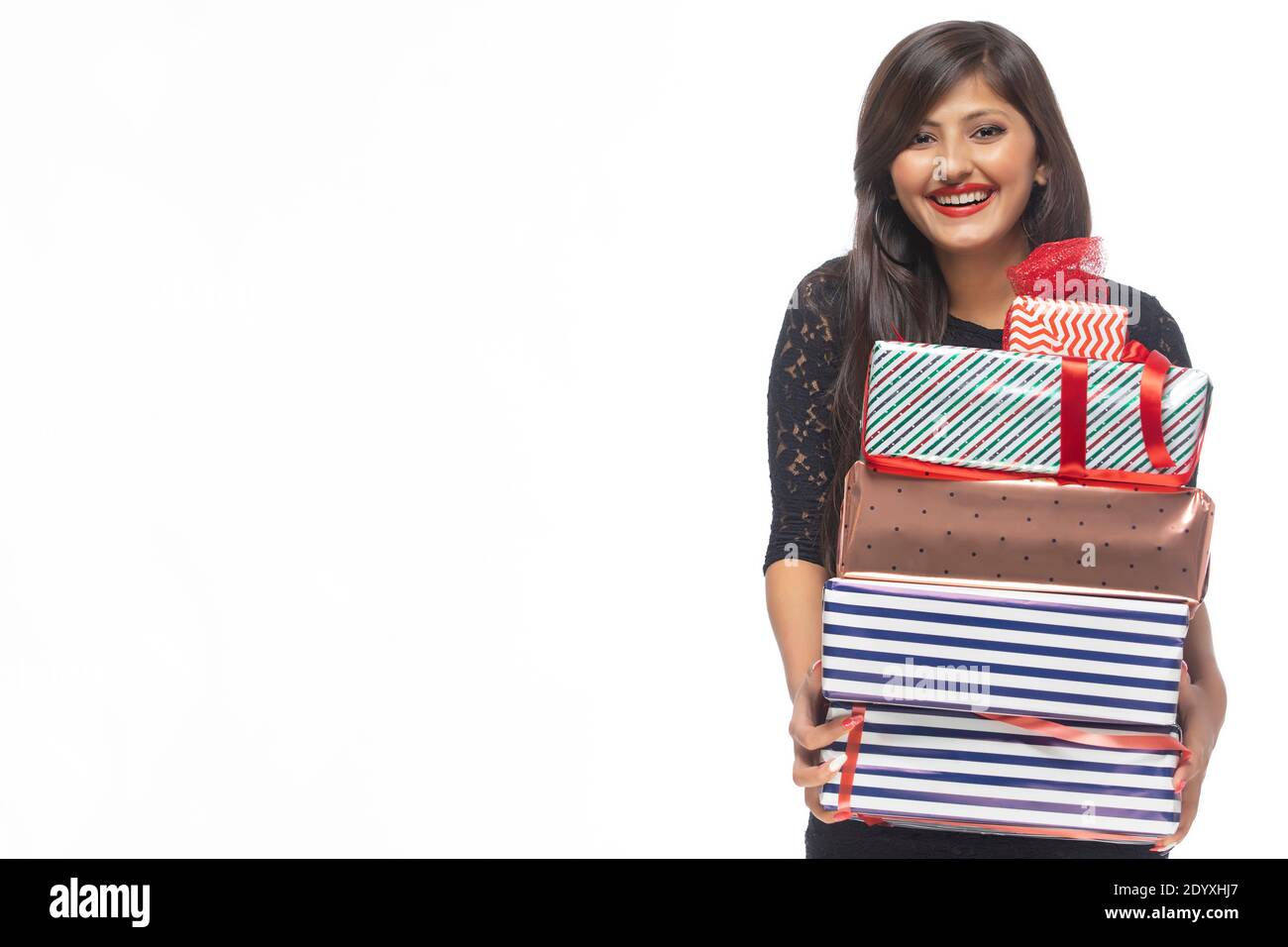 Portrait of young woman holding gift boxes Stock Photo