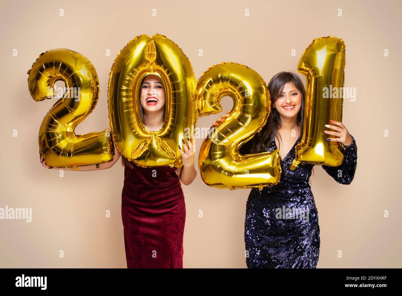 Young women holding 2021 golden balloons during a new year party Stock Photo
