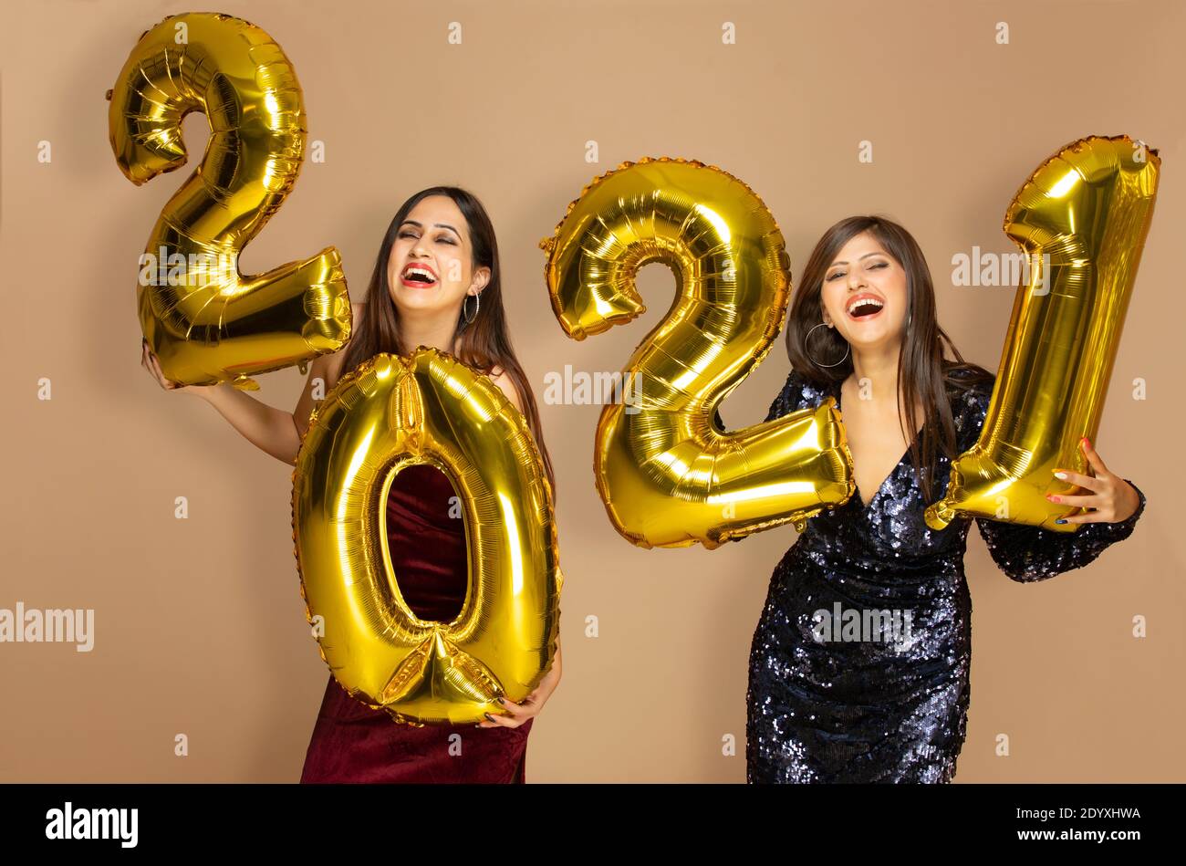 Young women holding 2021 golden balloons during a new year party Stock Photo