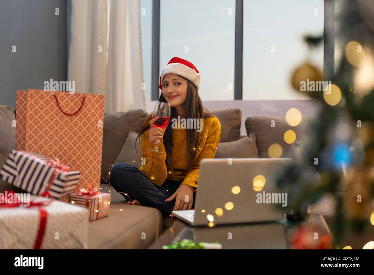 Happy Woman Making Video Call During Christmas wine party Celebration holding wine glass Stock Photo