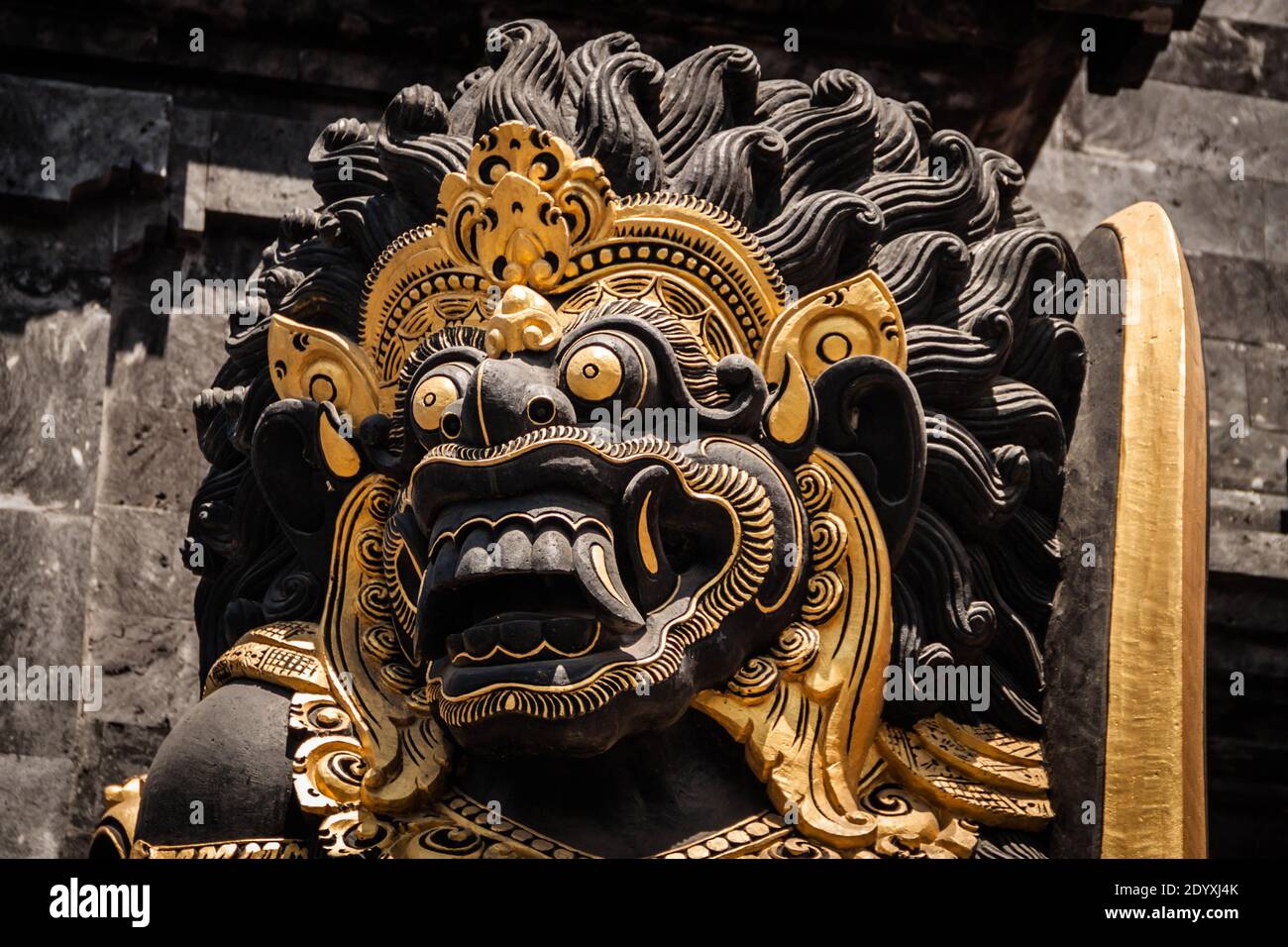 The giant black Dvarapala (gate guardian) with gold details at Tanah Lot Temple Stock Photo