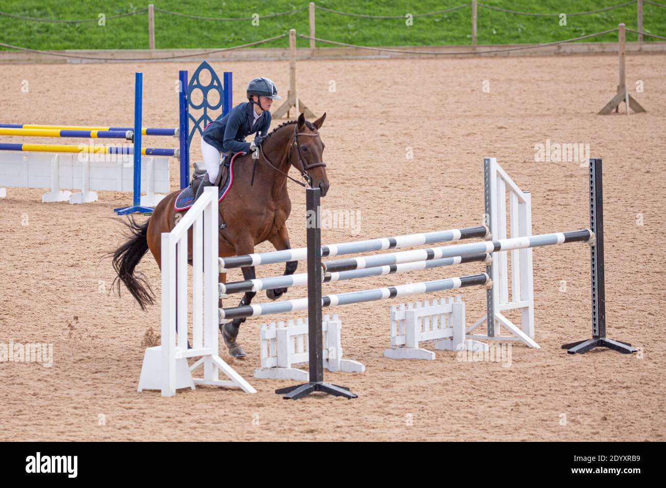 An equestrian rider on their horse jumping over a fence as they take ...
