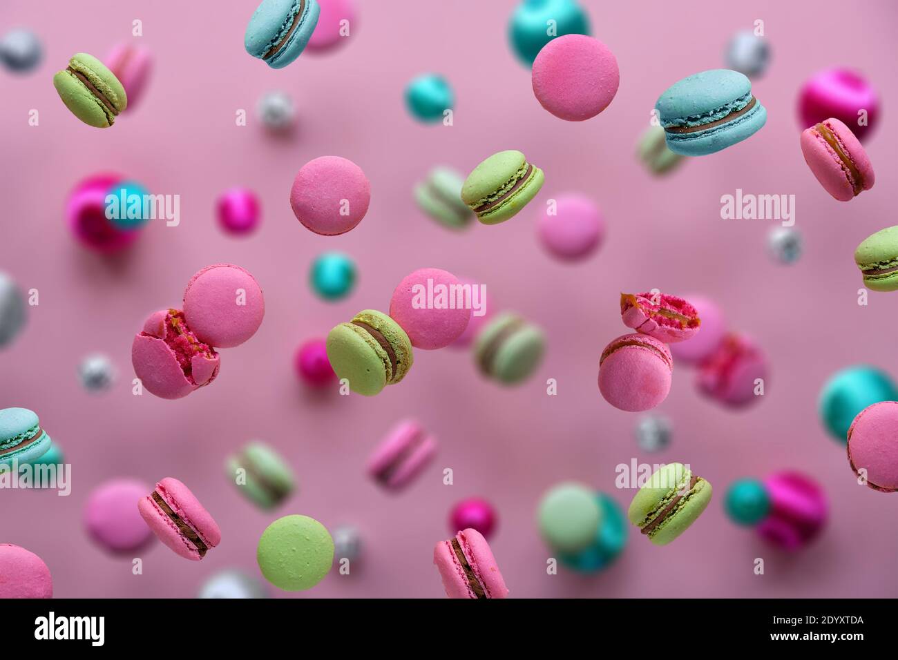 Levitation of macaroons, creative food concept. Bold vibrant pink, mint green, mint blue and magenta colors. Flying macaroons, disco balls and Stock Photo