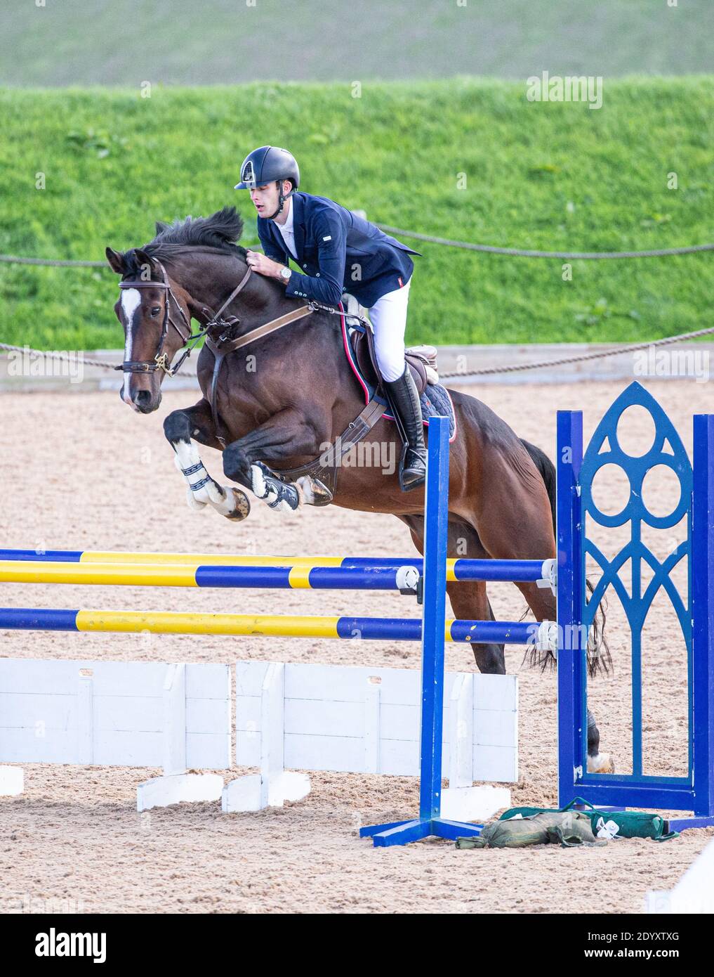 An equestrian rider on their horse jumping over a fence as they take ...