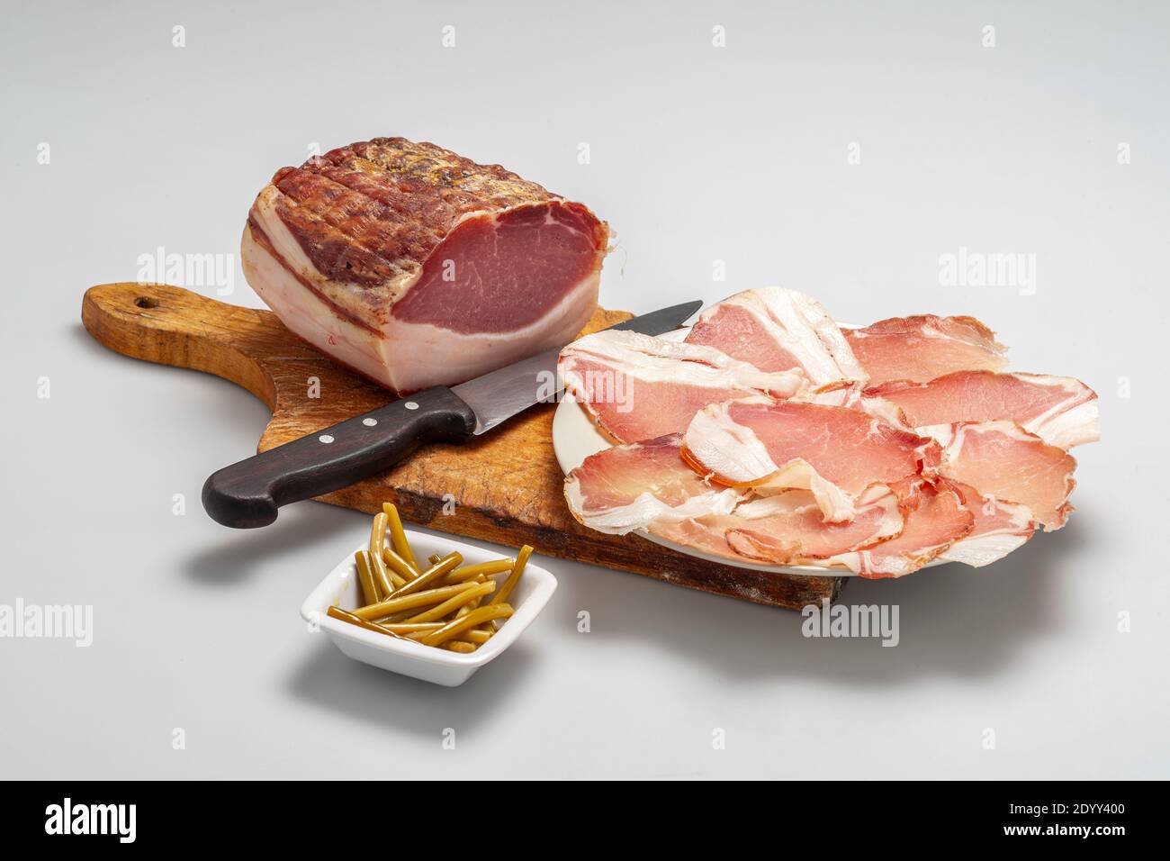 Capocollo ham platter accompanied by garlic tops. Abruzzo, Italy, Europe Stock Photo