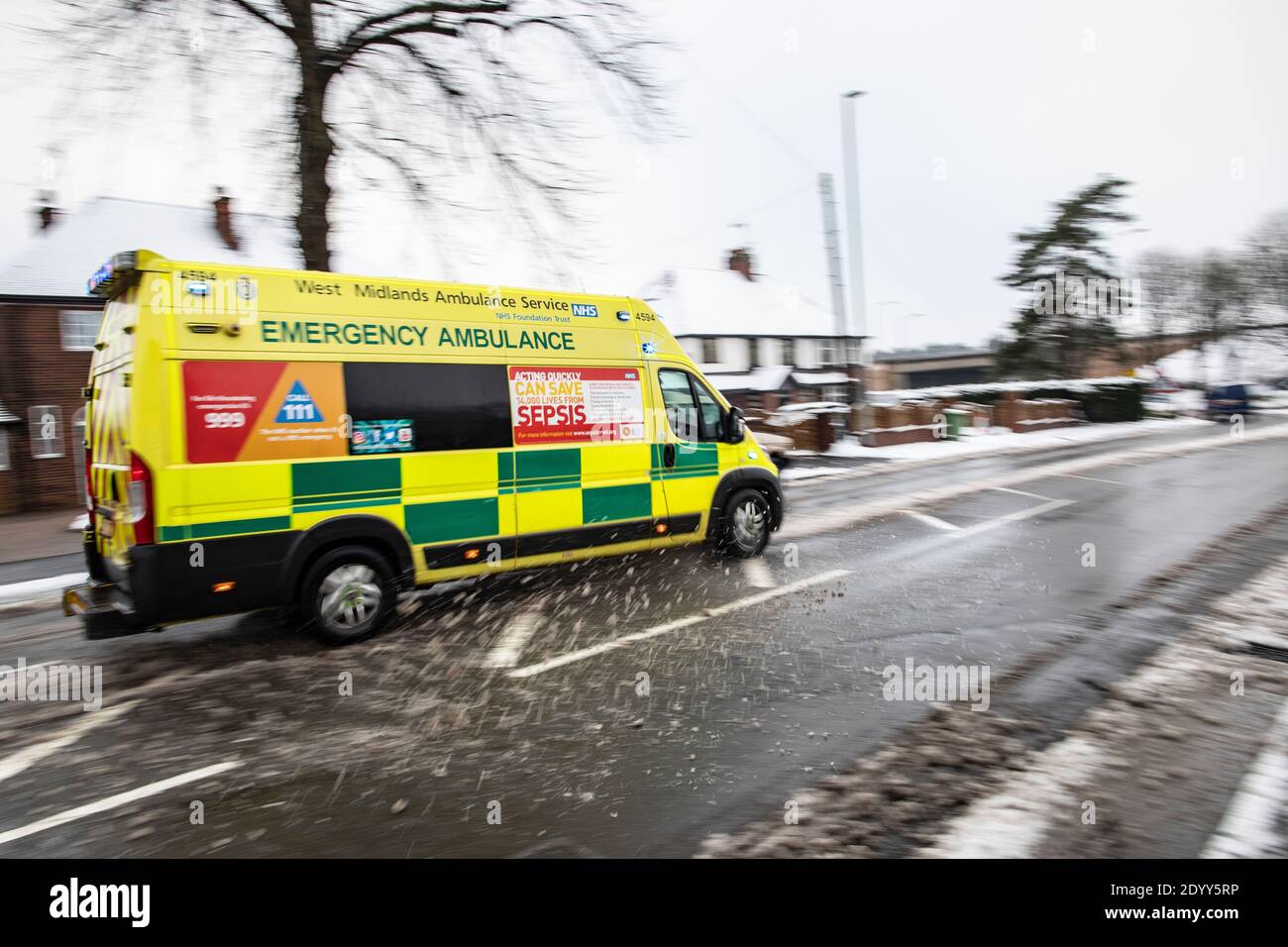 A West Midlands Emergency Ambulance on a 999 call in poor winter weather conditions Stock Photo