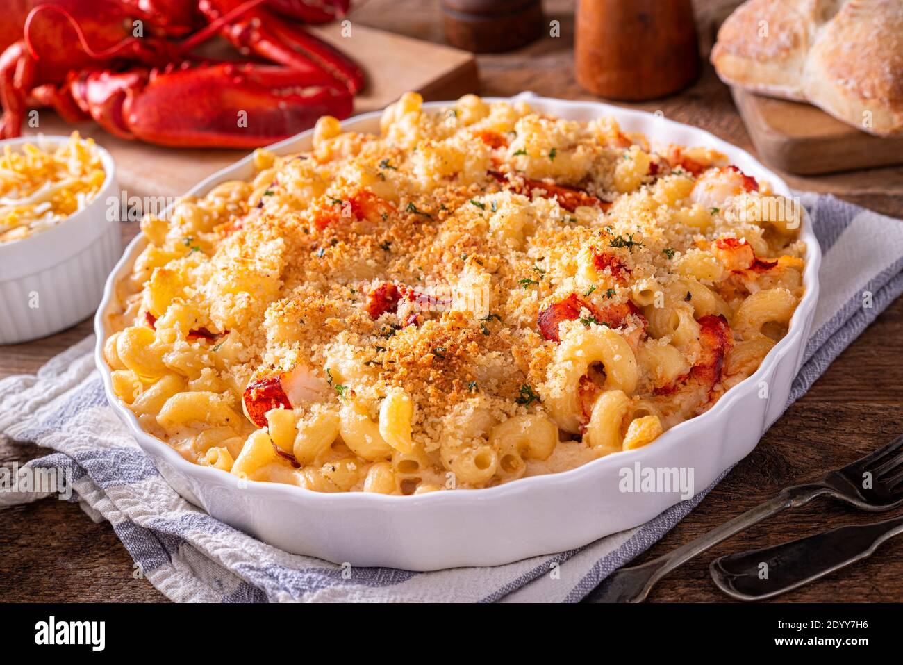 A delicious lobster macaroni and cheese casserole on a rustic wood table top. Stock Photo