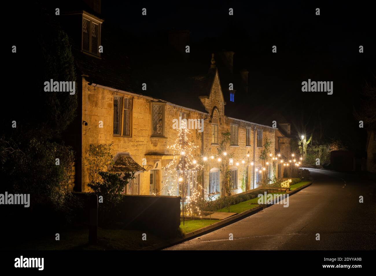 Christmas decorations and lights outside cottages at night in Broad