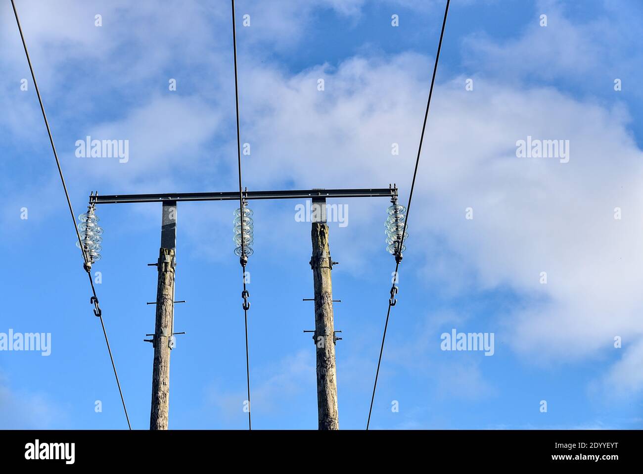 Overhead electrical power lines on old wooden pillar captured against