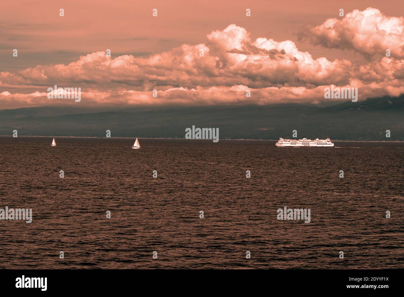 Orange view of the Ferry traffic on the Pacific Ocean, BC, Canada. Pacific ocean borders Western Canada. British Columbia's coastal weather is shaped Stock Photo