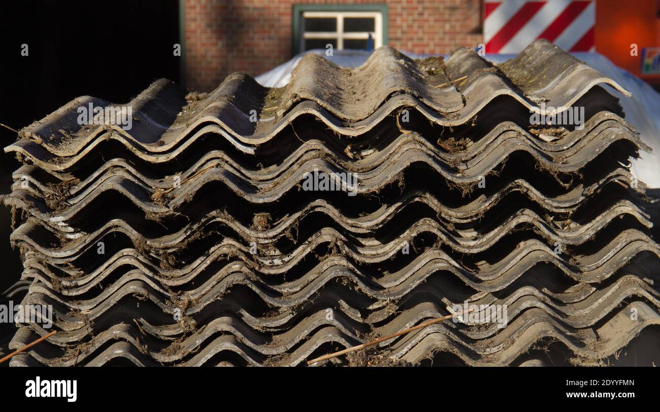 Stack of corrugated asbestos cement sheets, removed during remediation Stock Photo
