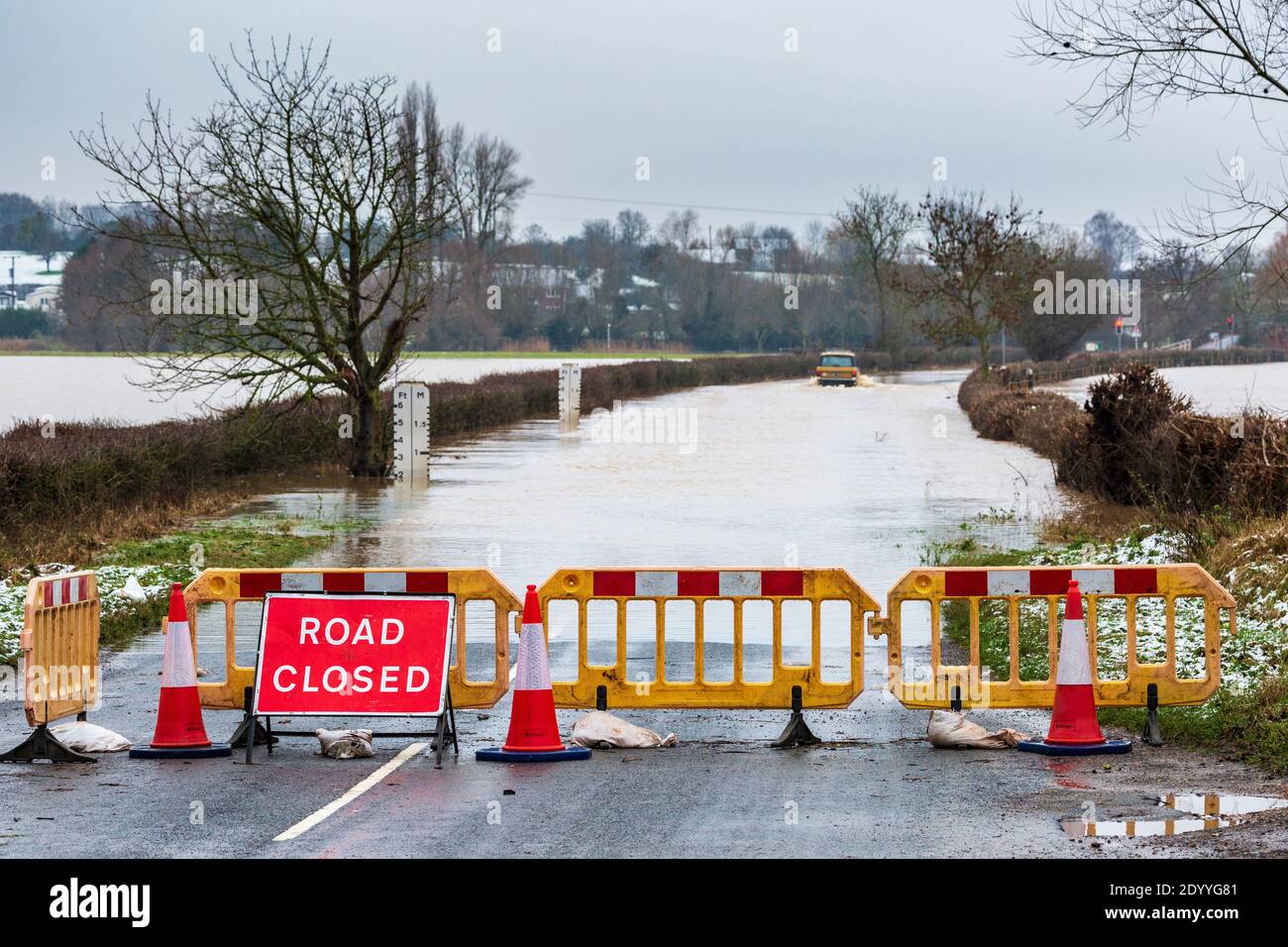 Road Closed due to flooding at Eckington bridge with a 4x4 driving through the receding flood water, Worcestershire, England Stock Photo