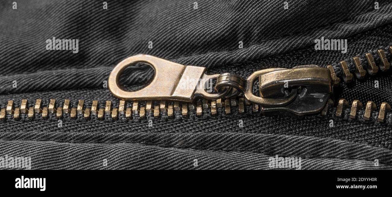 Macro close up of a golden zipper on a black jacket Stock Photo