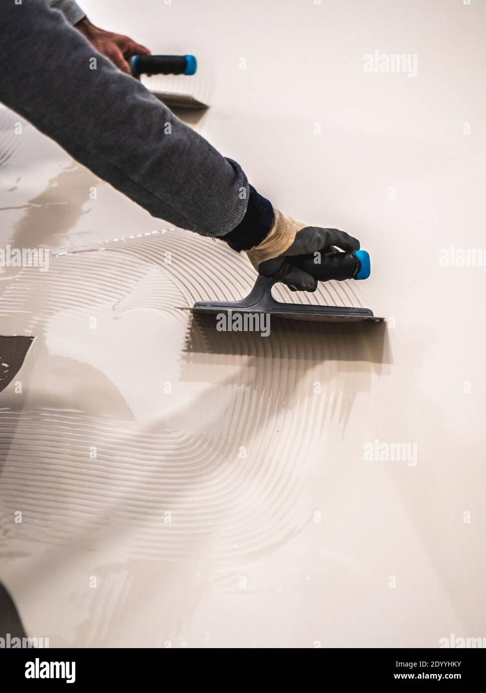 Worker applying a white epoxy resin bucket on floor Stock Photo Alamy