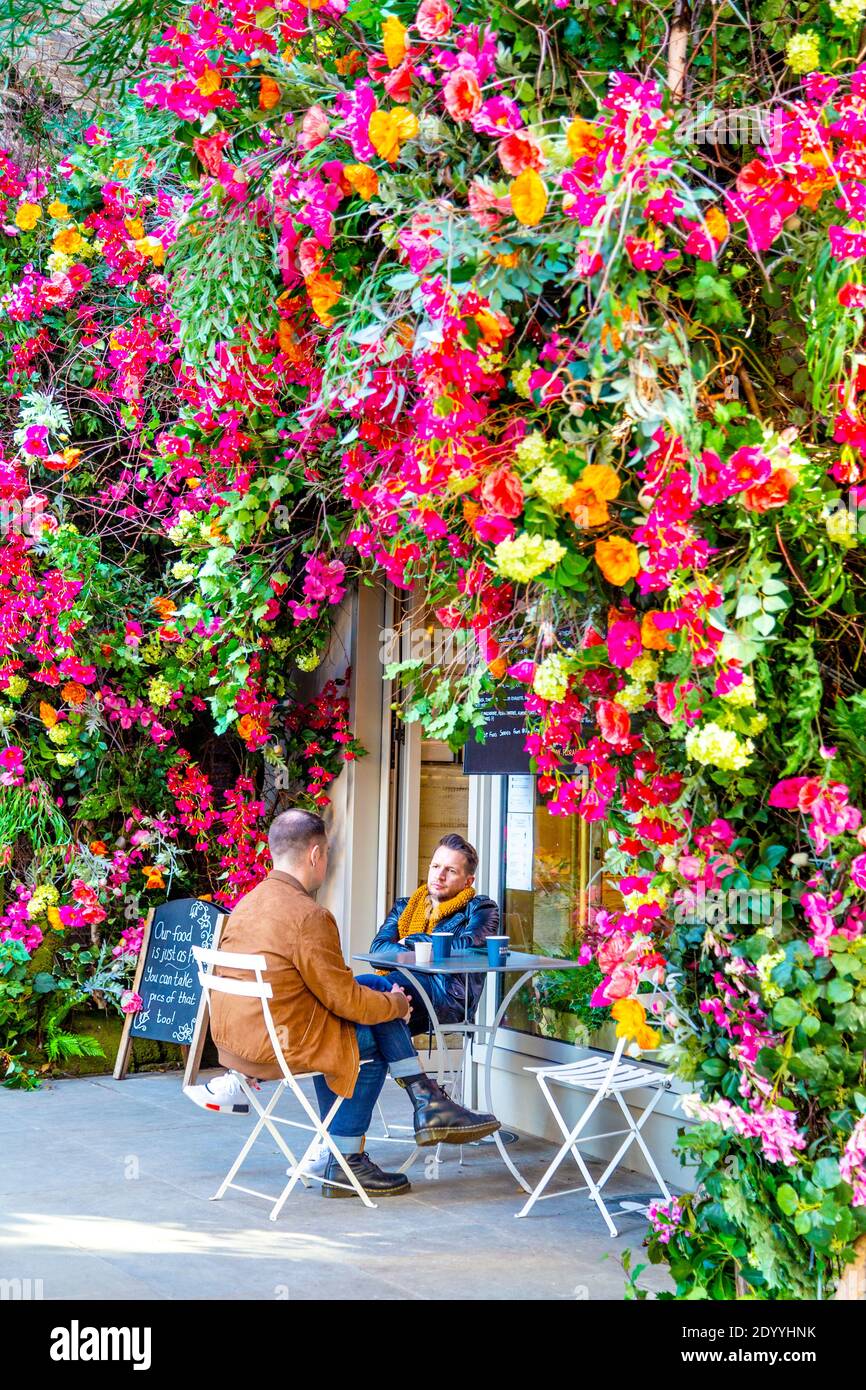 Exterior of Floral Street Coffee House decorated with colourful flowers, people having coffees outdoors, Covernt Garden, London, UK Stock Photo