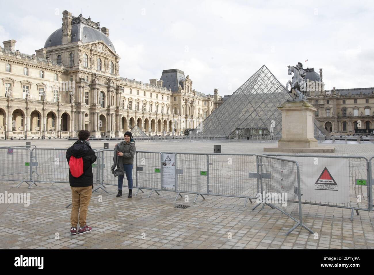 Paris, France. 28th Dec, 2020. A tourist pose for a photo at the deserted Napoleon courtyard near the closed Louvre museum amid the coronavirus pandemic on December 28, 2020 in Paris, France. According the latest report of the French National Authority for Health (HAS) 175 people died in hospital, and 8,822 new cases of Covid-19 infection, strict measures are still in place as curfew from 8:00 p.m. to 6:00 a.m. was put in place in all territory French. (Photo by Paulo Amorim/Sipa USA) Credit: Sipa USA/Alamy Live News Stock Photo