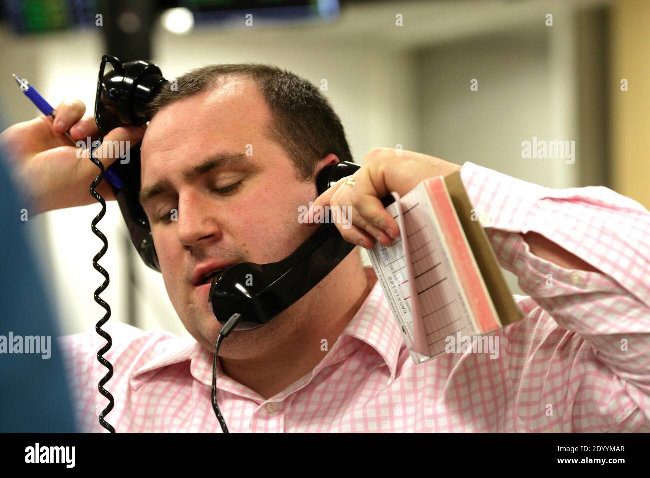 Great Britain/London/A broker talks on the many phones. Stock Photo