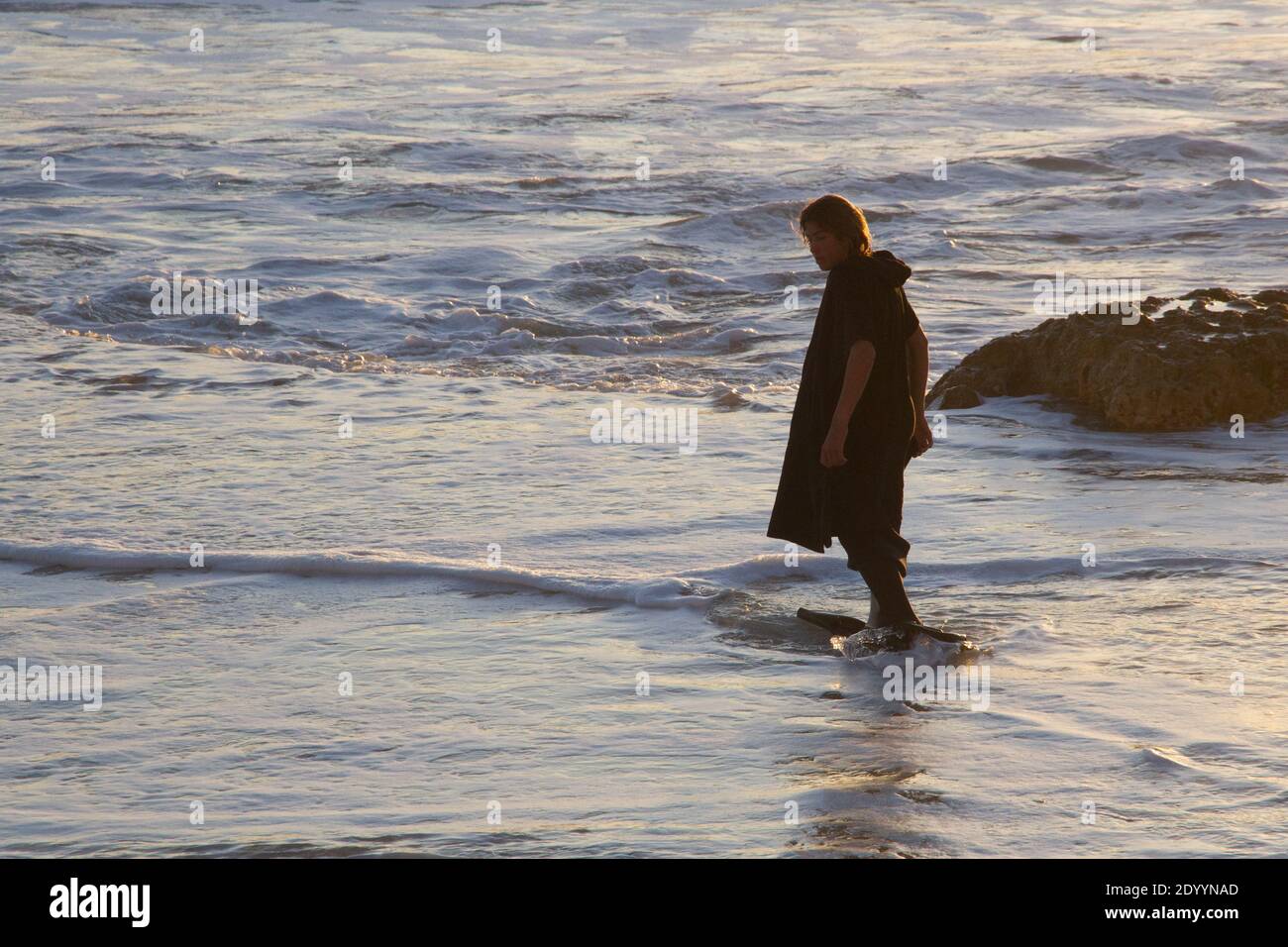 Post Covid lockdown, man wets his feet in sea water, Mallorca Spain Stock Photo