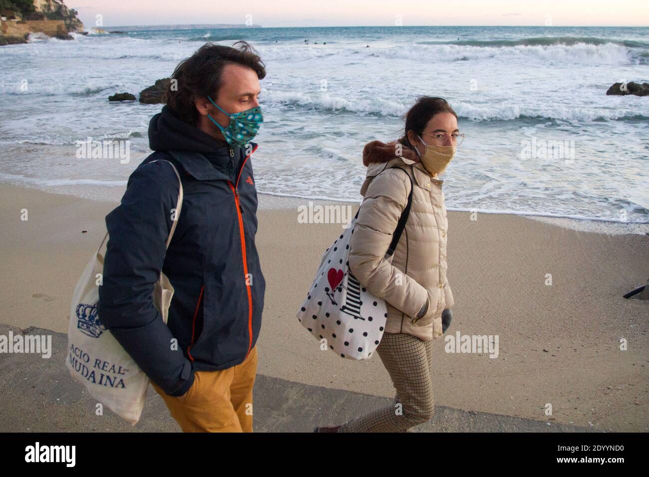 Post Covid lockdown, couple masks walking on beach in Mallorca Spain, Stock Photo