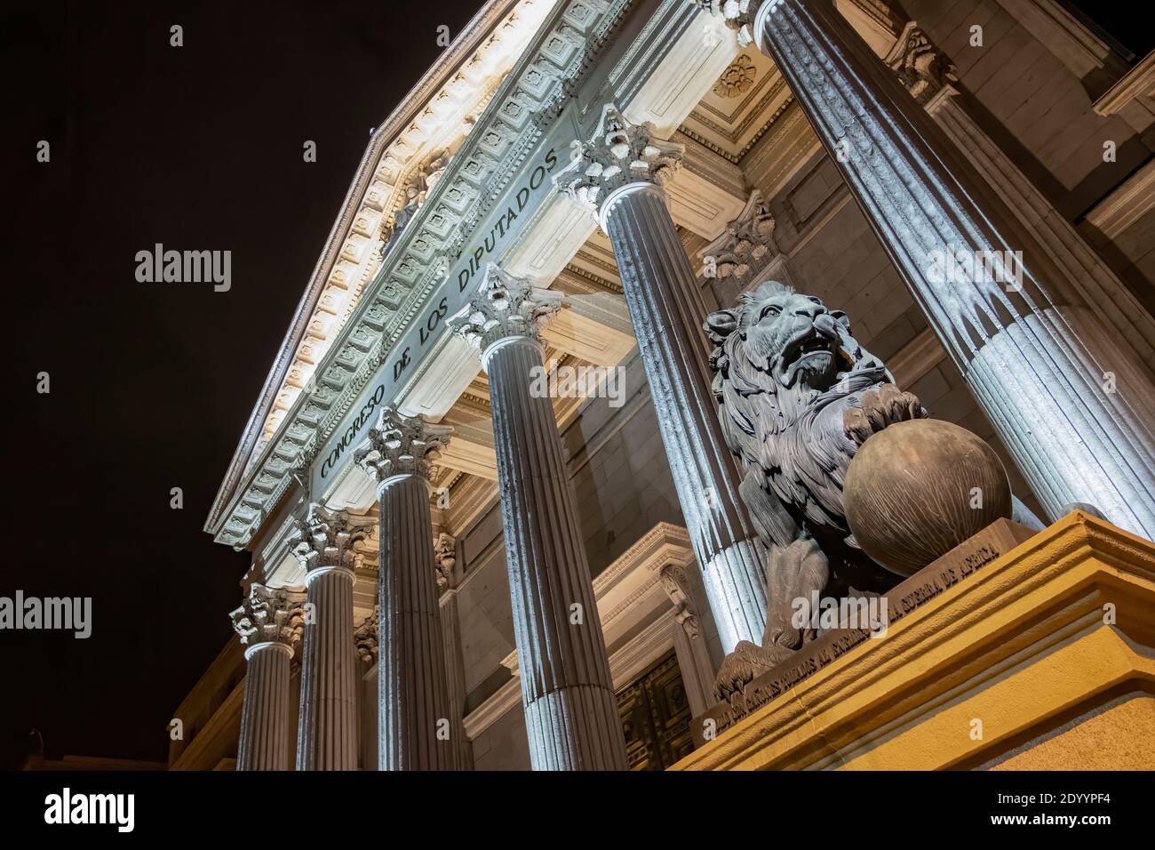 night view of the main facade of the Palacio de la Cortes, palace of courts, seat of the Congress of Deputies in Madrid, Spain, with one of its iconic Stock Photo