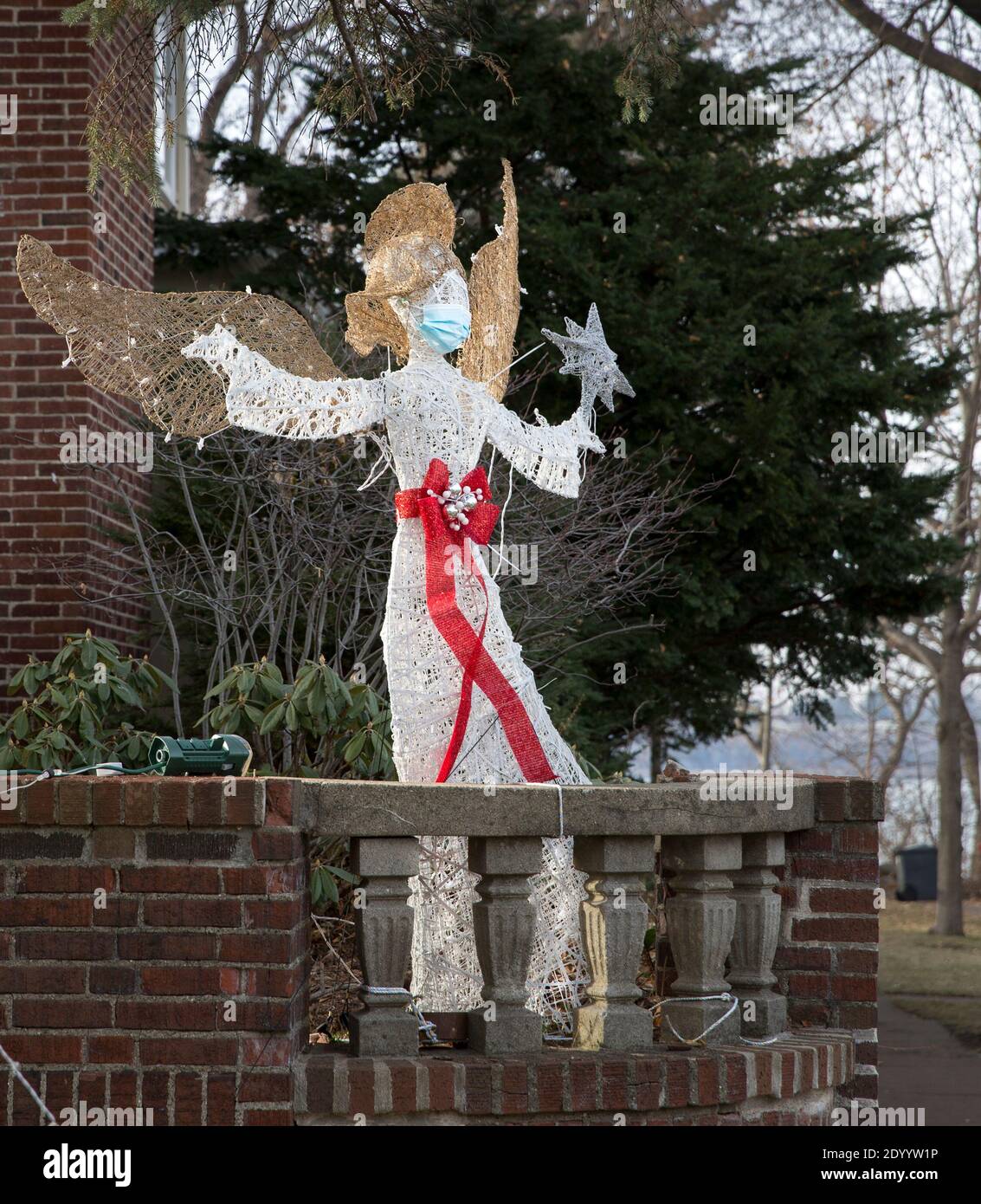 A Christmas yard lawn ornament of an angel wearing a face mask during the Covid 19 pandemic of 2020 Stock Photo