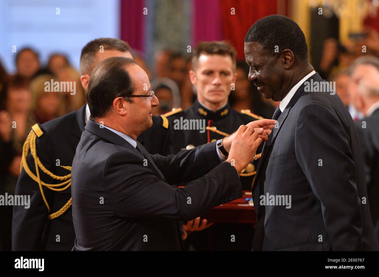 French President Francois Hollande (L) awards the Legion of Honor and National Order of Merit insignia to former Olympique de Marseille football club president Pape Diouf (R) during a ceremony to award French sports personalities at the Elysee Palace in Paris, France on October 9, 2013. Photo by Christian Liewig/ABACAPRESS.COM Stock Photo