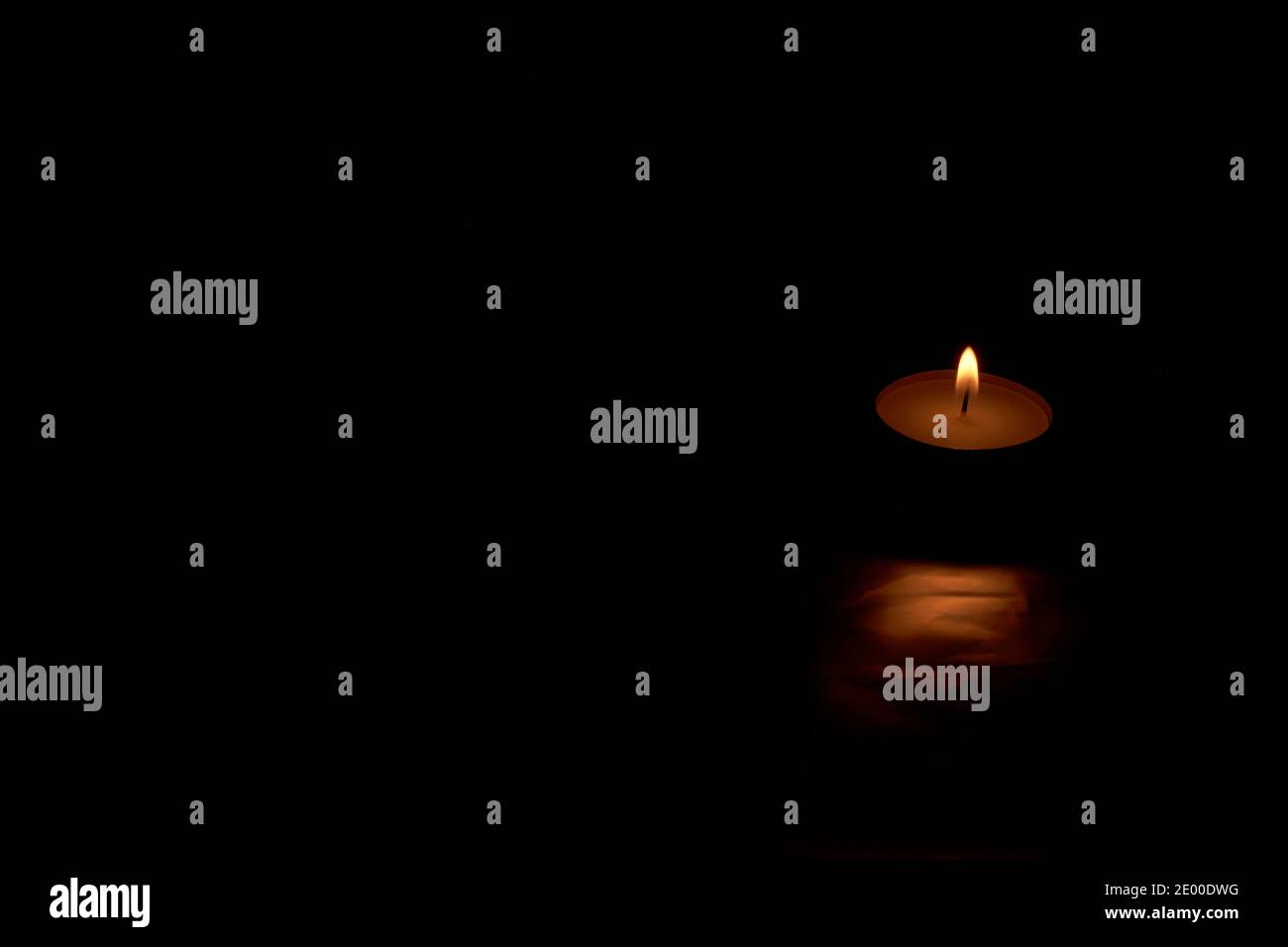 Small burning candle on black background. empty space, dark, for text Stock Photo