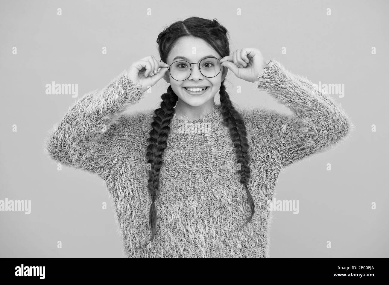 focus on what matters. cheerful teen has bad sight. Hair braided in braids. little beauty in glasses. happy childhood. small girl has nice smile. kid hairstyle fashion. smiling child with long hairdo. Stock Photo