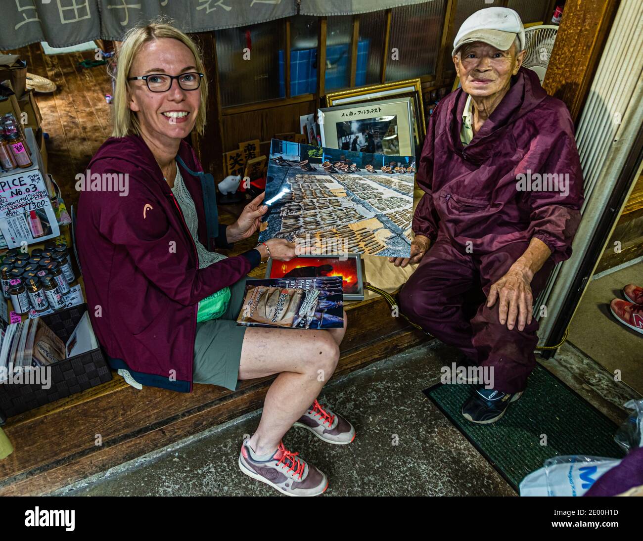 Memories of a busy life. Serizawa Senior shows reporter Angela Berg photos of his active time as head of the family business. Yasuhisa Serizawa's Katsuobushi Manufacture in Nishiizu-Cho, Shizuoka, Japan Stock Photo