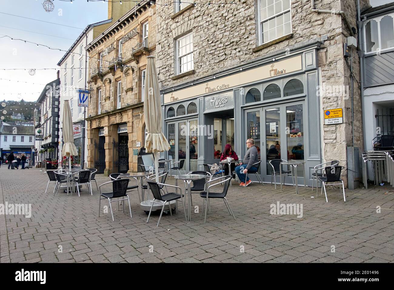 A quiet street cafe in a marketplace on Christmas Eve with few shoppers about due to the Covid 19 pandemic Stock Photo
