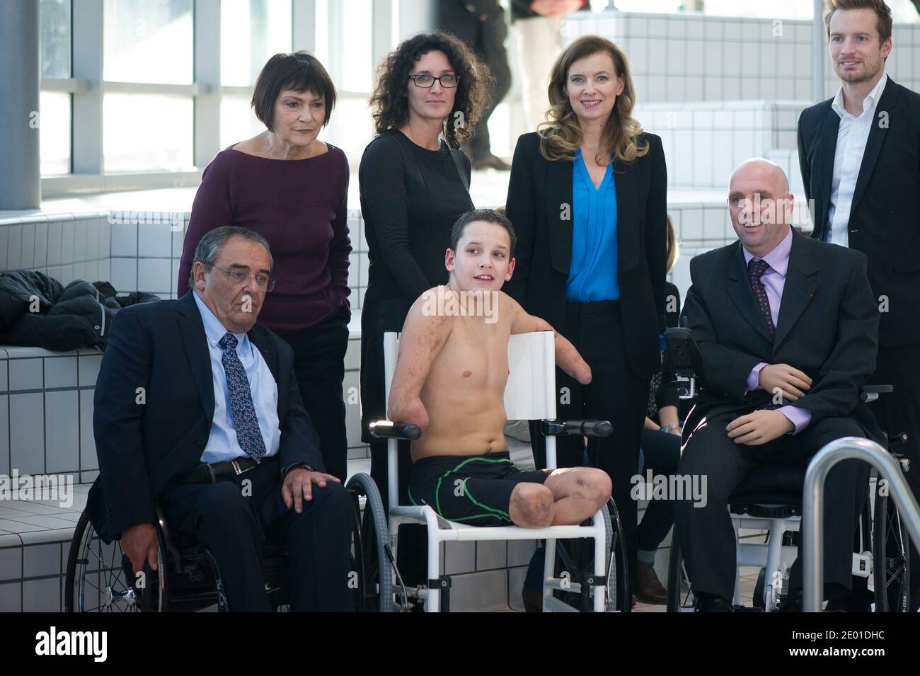 Junior Minister for Disabled People Marie-Arlette Carlotti and companion of France's President Valerie Trierweiler pose with Theo, a 13-year-old 4-limb amputee, next to his mother, four-member amputee swimmer Philippe Croizon, paralympic 100m butterfly - S8 champion Charles Rozoy and Handisports Federation President Gerard Masson on November 27, 2013 in Vichy, central France. Theo is a grant holder of the disabled sports branch of the French Expertise and Performance Ressource Centre (CREPS) of Vichy Auvergne, where he trains in swimming. In early 2013, he competed for the first time in the Fr Stock Photo
