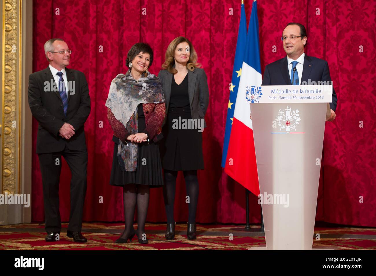 French President Francois Hollande delivers his speech watched by his companion Valerie Trierweiler and Junior Minister for the Disabled Marie-Arlette Carlotti during the annual awarding ceremony of La Medaille de la Famille Francaise (Medal of the French Family), at the Elysee Palace in Paris, France on November 30, 2013. The award is to honour those who have successfully raised several children with dignity. Photo by Nicolas Gouhier/ABACAPRESS.COM Stock Photo