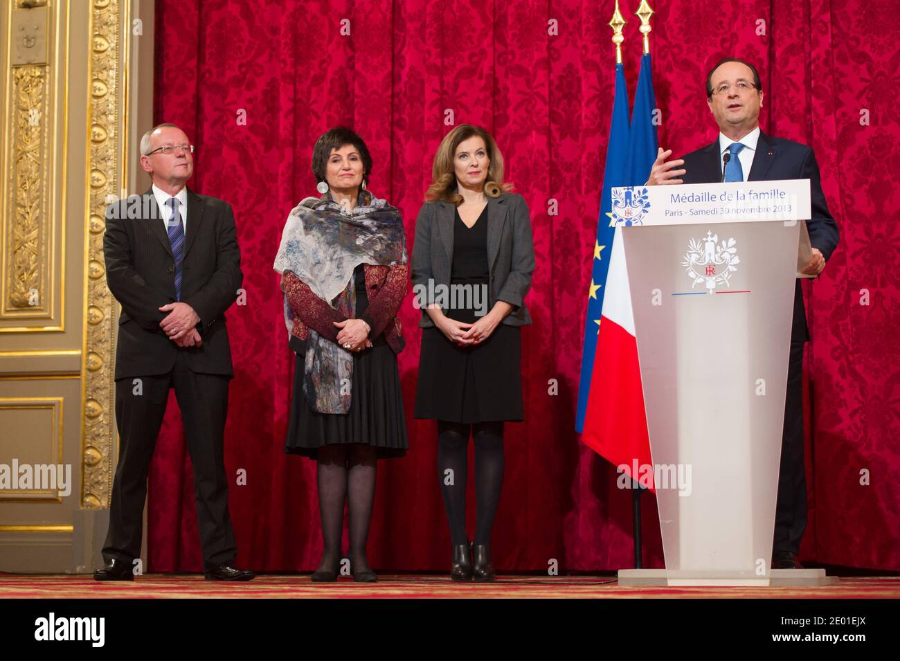 French President Francois Hollande delivers his speech watched by his companion Valerie Trierweiler and Junior Minister for the Disabled Marie-Arlette Carlotti during the annual awarding ceremony of La Medaille de la Famille Francaise (Medal of the French Family), at the Elysee Palace in Paris, France on November 30, 2013. The award is to honour those who have successfully raised several children with dignity. Photo by Nicolas Gouhier/ABACAPRESS.COM Stock Photo
