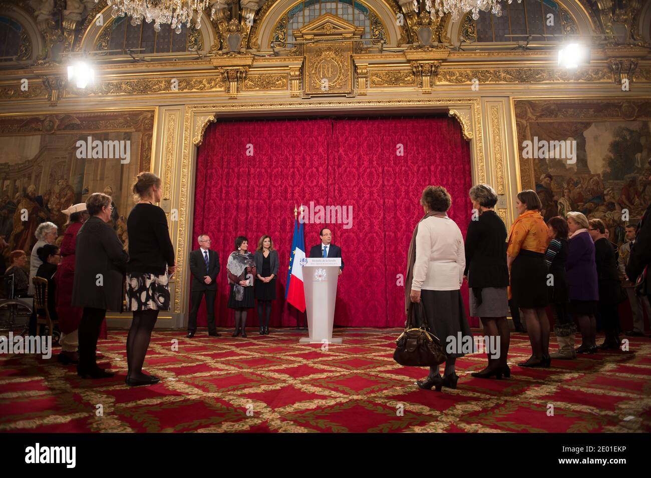 French President Francois Hollande delivers his speech watched by his companion Valerie Trierweiler and Junior Minister for the Disabled Marie-Arlette Carlotti during the annual awarding ceremony of La Medaille de la Famille Francaise (Medal of the French Family), at the Elysee Palace in Paris, France on November 30, 2013. The award is to honour those who have successfully raised several children with dignity. Photo by Nicolas Gouhier/ABACAPRESS.COM Stock Photo