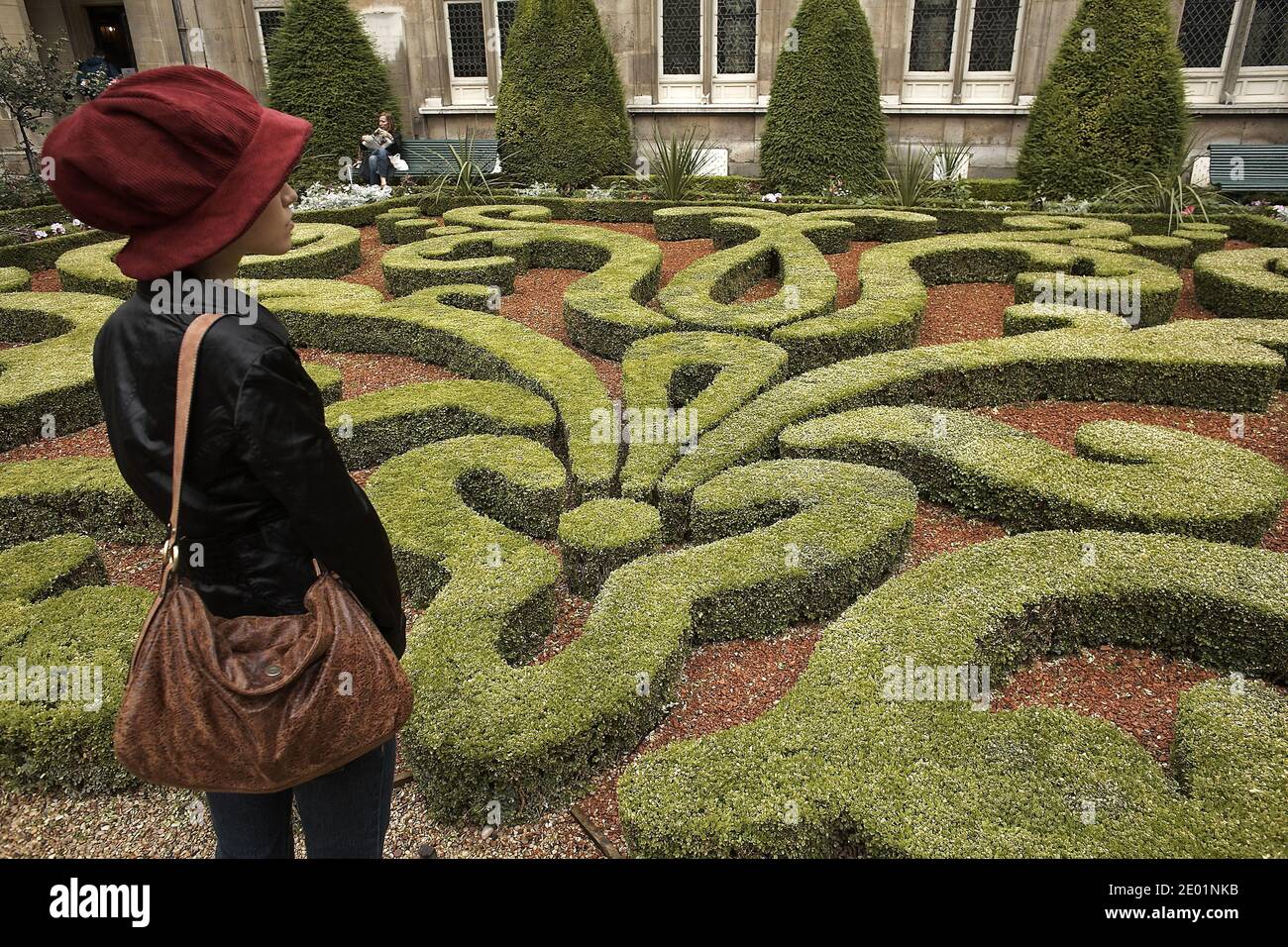 FRANCE / Paris/ Le Marais /Girl with red hut looking at the garden in Musee Carnavalet. Stock Photo