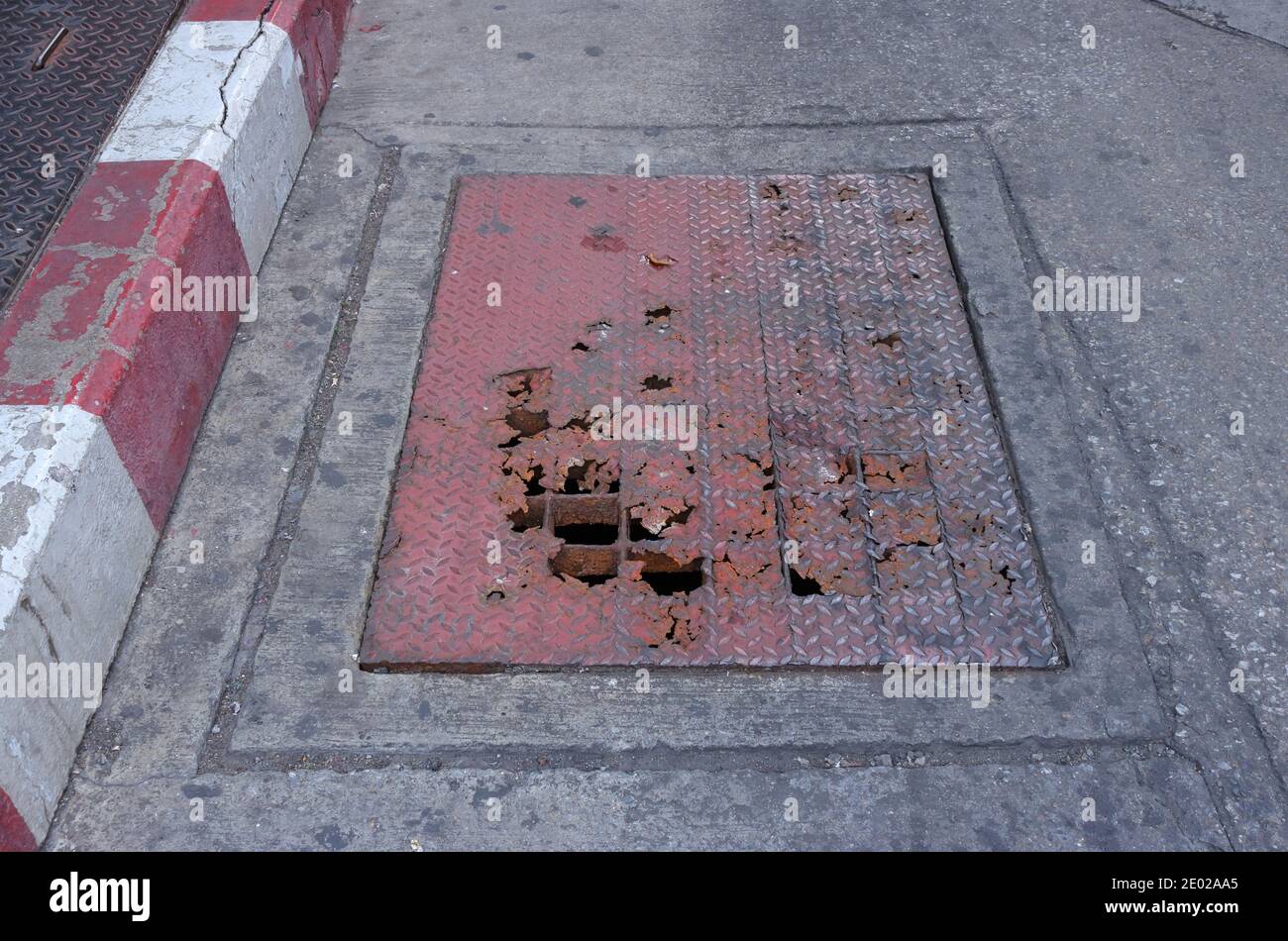 Selective focus of broken steel drain cover on street Stock Photo