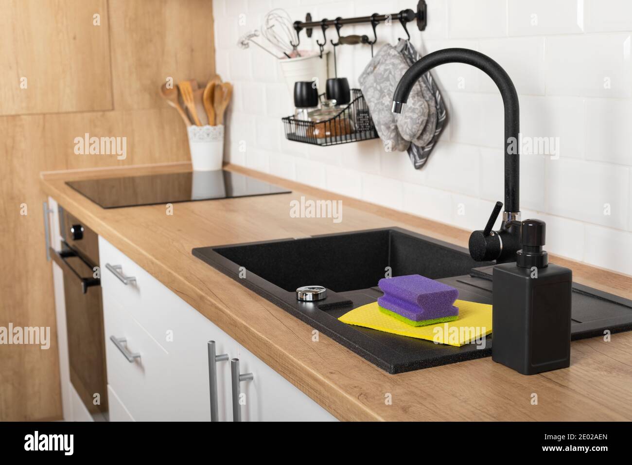 Close up picture of a clean wooden kitchen countertop and black sink ...