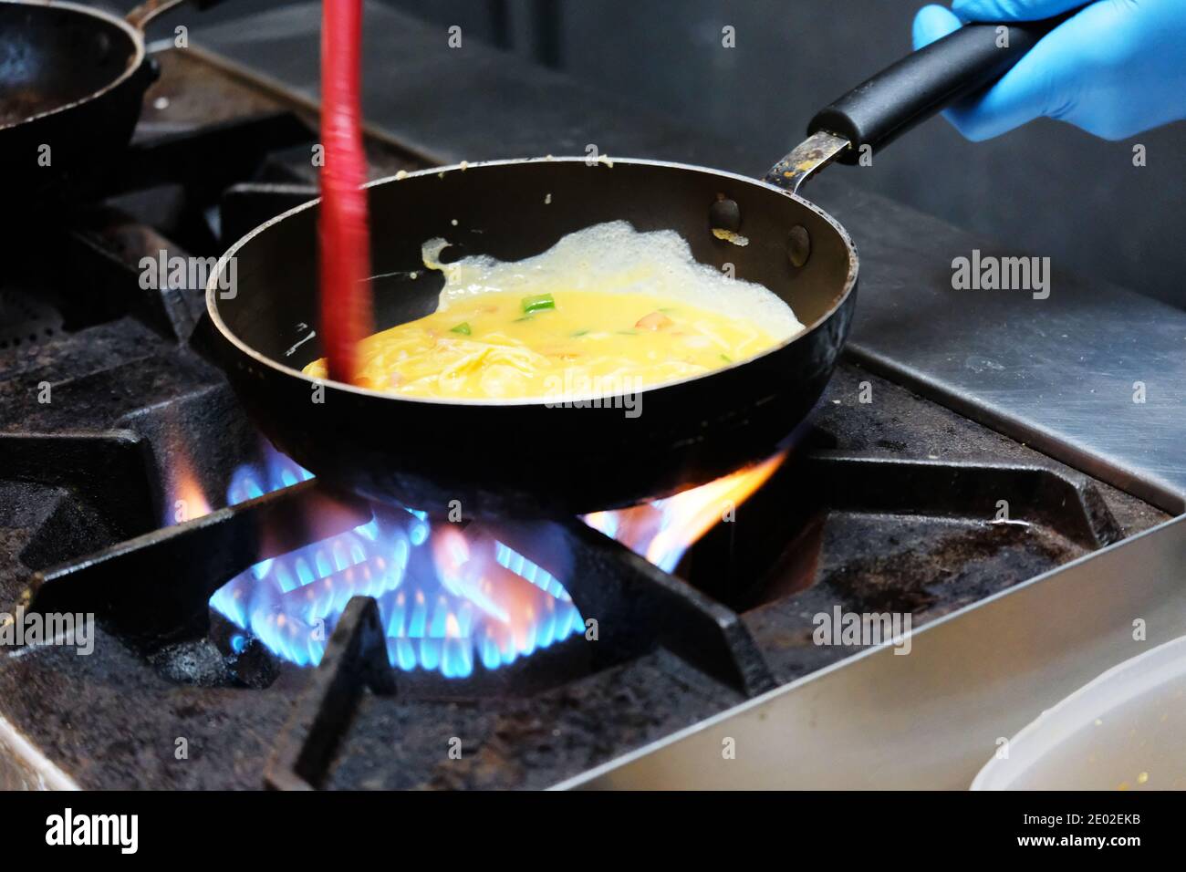Frying egg in a pan on hot gas stove Stock Photo