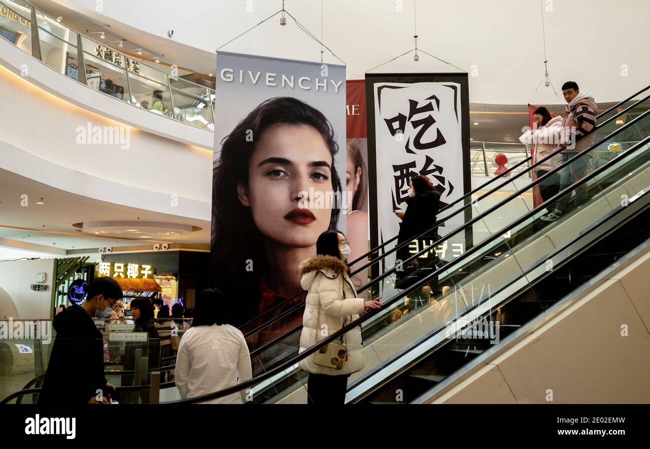 People, wearing face masks, are shopping in a shopping mall Stock Photo