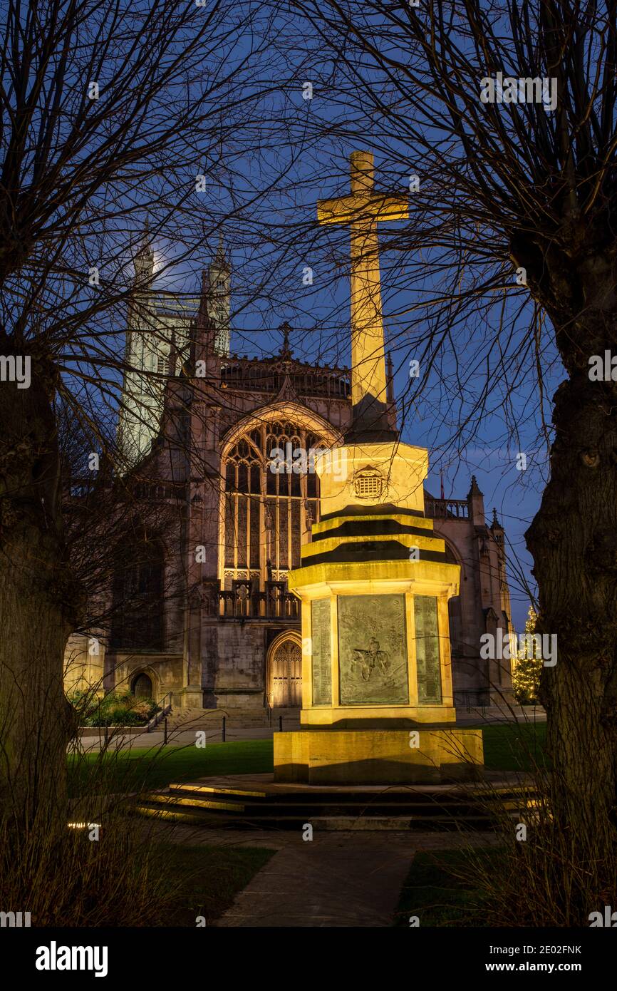 College green war memorial lit up in front of Gloucester Cathedral on Christmas Day at dusk. Gloucester, Gloucestershire, Cotswolds, England Stock Photo